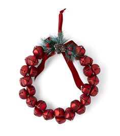 a red christmas wreath with bells and a pine cone