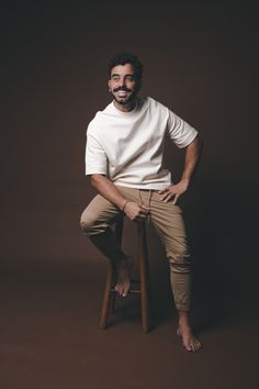 a man sitting on top of a wooden stool