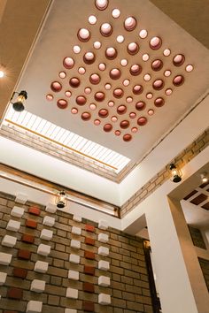 the ceiling is decorated with pink and white polka dotes on brick walls, along with several lights