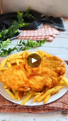 fish and fries on a white plate with parsley