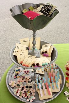 a metal tray with lots of different types of buttons and pins in it on top of a table