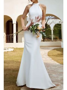 a woman in a white dress holding flowers