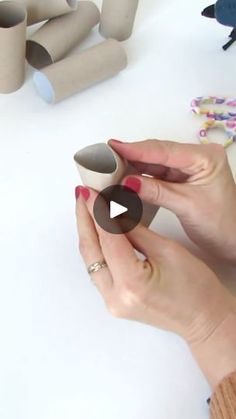 a woman is making some paper tubes out of toilet paper and glue on the table