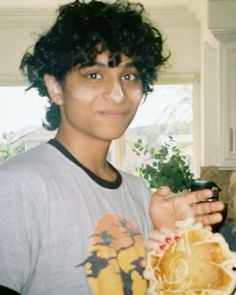 a young man holding a plate of food in his hands