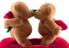 two teddy bears sitting on top of each other kissing with their noses close to one another