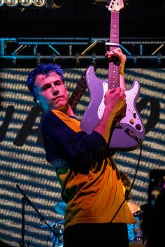 a young man is playing an electric guitar