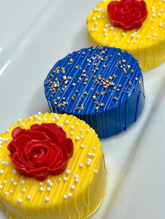 two cakes decorated with icing and sprinkles are sitting on a white surface