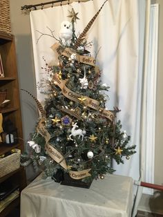 a small christmas tree decorated with ribbons and ornaments