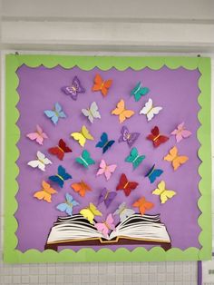 an open book with colorful butterflies flying out of it on a purple and green background