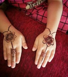 two hands with henna tattoos on them