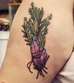 a woman's arm with a tattoo on it that has plants growing out of it