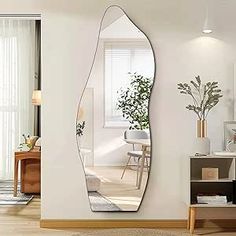 a living room with a large mirror on the wall next to a table and chair