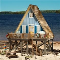 a small beach house on the sand near water