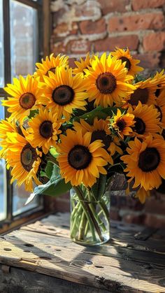 a vase filled with yellow sunflowers sitting on top of a wooden table next to a window