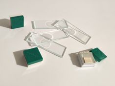 several pieces of glass sitting on top of a white table next to some green tape