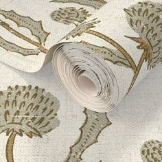 a wallpaper with gold and white flowers on the side, it has a roll of paper in front of it