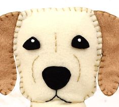 a close up of a stuffed dog on a white surface with black eyes and nose