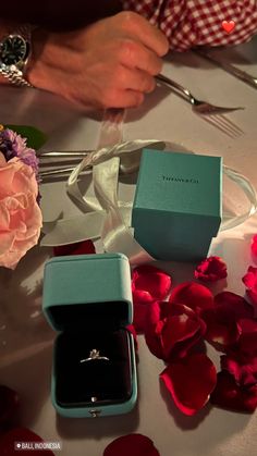 a couple of rings sitting on top of a table next to some flowers and scissors