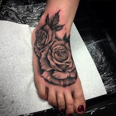 a black and white rose tattoo on the foot