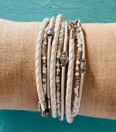 White Leather Bracelet wraps around your wrist 3 times and is secured with a clasp. It consists of 3 Seperate strands. FEATURES: *One cord of genuine white leather *One cord of genuine white braided leather  *1 strand white and pearl seed beads *Silver Tibetan Beads *lobster clasp with extension chain SIZING: (see image 6) 1. Measure your wrist snugly above the bone with a tape measure 2. Use a piece of string and lay against a ruler if no tape measure is available 3. Choose your Exact wrist measurement from the dropdown menu **Extra length is added so that when you wrap the bracelet around your wrist, it will fit comfortably.  Designs by Noa - Electic, unique celebrity inspired jewelry custom made for discerning ladies. Boho Wrap Bracelets: https://www.etsy.com/il-en/shop/DesignsbyNoa?ref Boho Wrap Bracelet, Seed Bead Bracelet, Simple Leather, Simple Bracelets, Seed Bead Bracelets, Leather Wrap Bracelet, Gift For Girlfriend, Leather Cuffs, Braided Leather