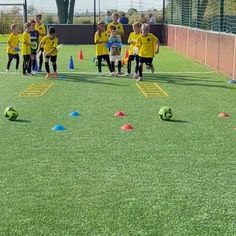 children are playing soccer on the field with cones and balls in front of their backs