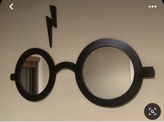 a pair of round mirrors mounted to the side of a wall with lightning bolt on it