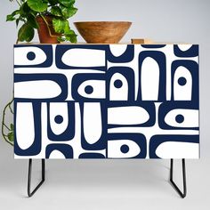 a blue and white cabinet sitting next to a potted plant on top of a table