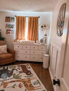 a living room with a couch, dresser and baby crib