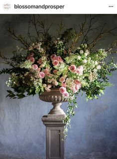 a vase filled with lots of flowers on top of a table