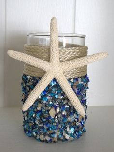 a starfish is sitting on top of a jar filled with blue and white beads