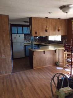 an empty kitchen and living room with hard wood flooring in the middle of it