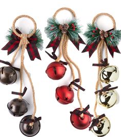 christmas bells hanging from twine with bows and decorations around them, on white background