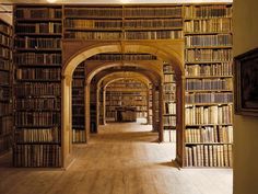 an old library with lots of books lined up on the walls and wooden flooring