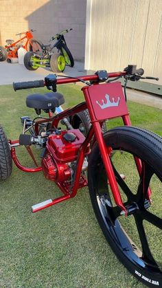 a red and black bike parked in the grass