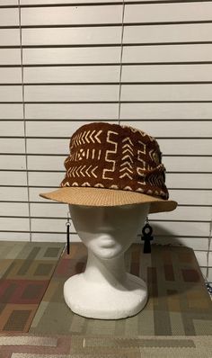 This is a rustic mudcloth fedora that is great for Spring and Summer. The fedora is accented with mudcloths from Mali. This african hat is also accented with trade beads. Don't delay order yours today. Brown Woven Bucket Hat, Casual Brown Hat For Festival, Brown Casual Festival Hat, Casual Brown Festival Hat, Brown Bucket Hat For Festival, Woven Fedora Hats, One Size Fits Most, Brown Brimmed Bohemian Straw Hat, Brimmed Brown Crochet Hat For Festival, Traditional Wide Brim Fitted Hat