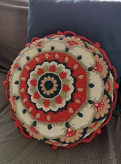 a crocheted decorative pillow sitting on a couch