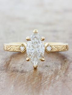 a yellow gold ring with an oval cut diamond