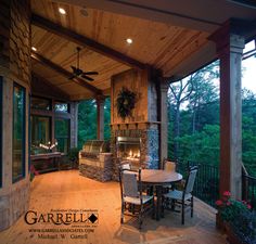 a covered patio with table and chairs next to an outdoor fireplace in the middle of it