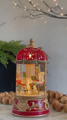 a red and gold lantern sitting on top of a table next to some nuts with lights in the background