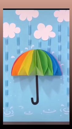 someone is holding an origami umbrella in front of a blue background with clouds