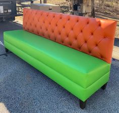 an orange and green couch sitting on the ground