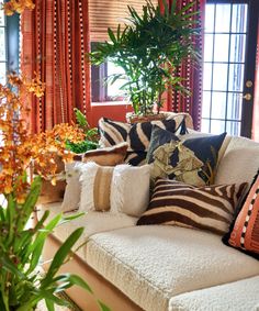 a living room filled with lots of furniture and plants