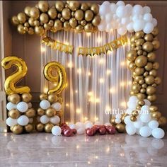 the balloon arch is decorated with gold and white balloons