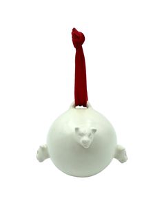 an ornament shaped like a white ball with a red ribbon on top