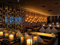 a restaurant with candles lit up in front of the windows and wooden screens on the wall