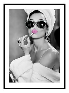 a woman with sunglasses and a towel on her head is holding a pink lip in front of her face