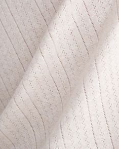 the textured fabric is white and has small dots on it, as well as lines