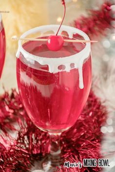 two glasses filled with red liquid and topped with a cherries garnish on the rim