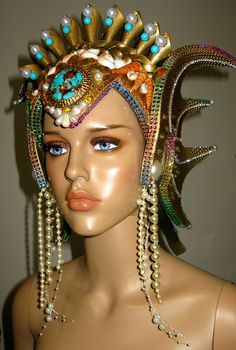 Ocean Queen Headdress, was made in strong but very light weight foam, decorate with gold paint, glitter, natural and handmade shells, rhinestones, pearls, metallic trims, natural turquoise beads and a natural turquoise and cooper front stone. The headpiece is lined with felt and have adjustable elastic on the back. Any question let me know. Thank you Whimsical High Crown Costume Hat, Whimsical Costume Hat With Tall Crown For Costume Party, Whimsical Tall Crown Costume Hat For Costume Party, Whimsical Costume Hat With Tall Crown For Parties, Handmade Tall Crown Headpiece For Costume Party, Fantasy Costume Party Hat With Round Crown, Fantasy Round Crown Costume Hat For Costume Party, Fantasy Costume Hat With Round Crown For Costume Party, Handmade Tall Crown For Costume Party