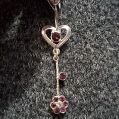 a close up of a heart shaped brooch with two flowers attached to it's side